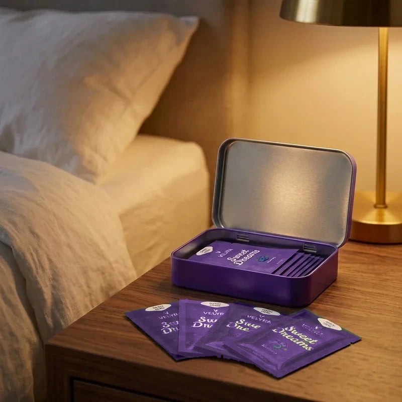 Individually wrapped Velyra sleep strip sachets and travel tin on nightstand